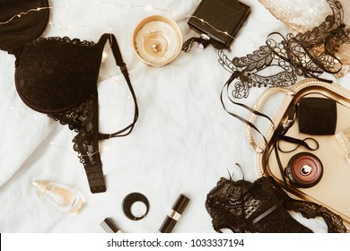 Top view fashion gold and black  accessories. Mask, coffee, lipstick and lace lingerie. Set of woman essential accessory and underwear on flat lay.