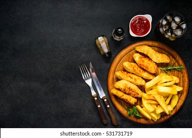 Top View Of Fast Food With Cold Cola, Ketchup, Chicken Fingers And Fried Potatoes On Copy Space Area