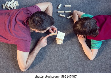 Top View Of Father And Son Playing Jenga Game At Home