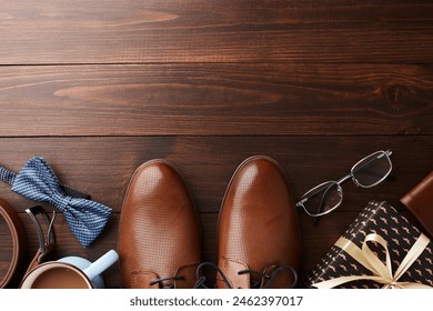 Top view of Father's Day essentials with blue accents, including shoes, tie, and a gift on wooden backdrop, ideal for articles or promotions on how to celebrate dads - Powered by Shutterstock