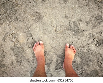 top view of feet stand on sand beach concept for holiday,journey,sea,travel,relaxing