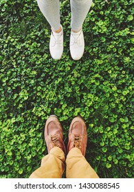 Top view of feet of young couple on grass ground