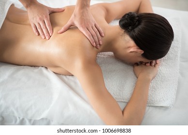 Top view of female back getting relaxation massage. Girl is lying on massage table with pleasure - Shutterstock ID 1006698838