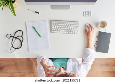 Top View Of A Female Doctor Talking On The Phone At Her Desk