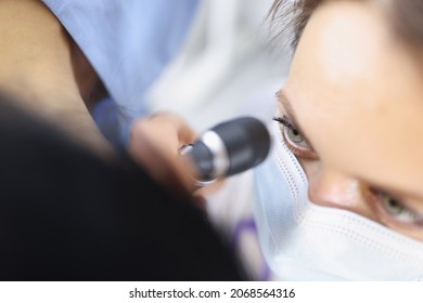 Top View Of Female Ent Doctor In Medical Mask Examining Ear With Otoscope Carefully