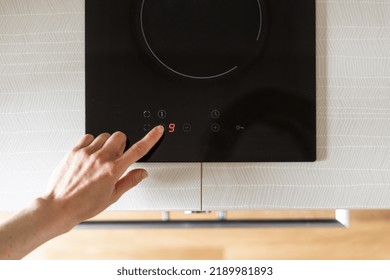 Top View Of Female Hand Choose Temperature On Control Panel Of Glass Ceramic Stove On Countertop In Home Kitchen