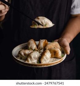 Top view of female hand with chopstick picking Dimsum dumplings on the table in Chinese restaurant - Powered by Shutterstock