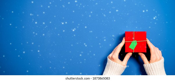 top view of female hands holding Christmas gift - Shutterstock ID 1873865083