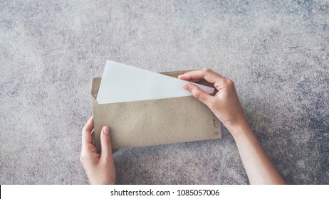 Top View Of Female Hands Opening Envelope
