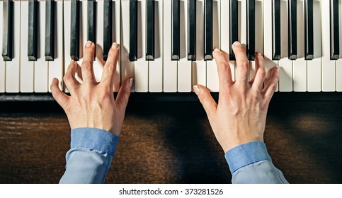 Top View Of Female Hands Playing The Piano 