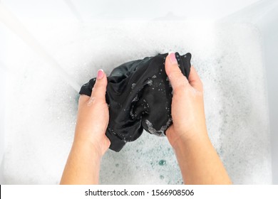 Top View Of Female Hands Washing Black Clothes