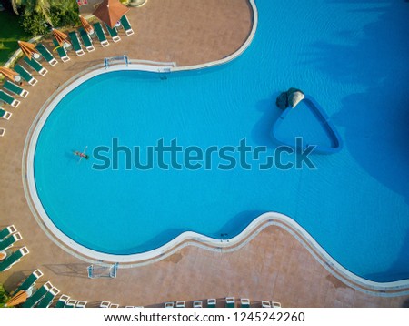 Top view of female in red bikini lying in swimming pool. 