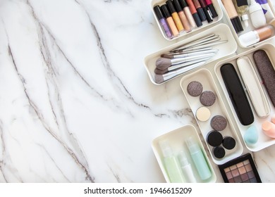 Top View Of Female Visagiste Is Neatly Placing Cosmetic And Vanity Items In MUJI's PP Makeup Storage Boxes With Various Sizes On White Marble Dressing Table. Decluttering And Organization Concept.