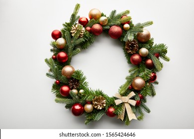 top view of festive Christmas wreath with baubles on white background - Shutterstock ID 1565424646