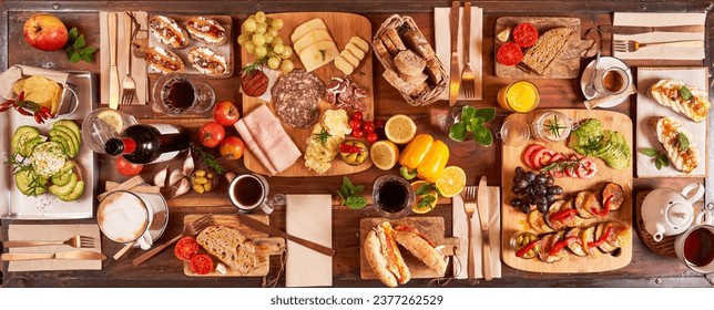 Top view of few charcuterie boards with various snacks with vegetables and bread served with drinks and cutlery in light kitchen - Powered by Shutterstock