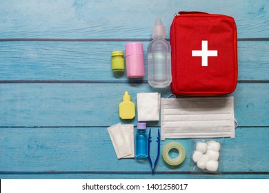 Top View First Aid Bag Kid With Medical Supplies  On Wood Background.