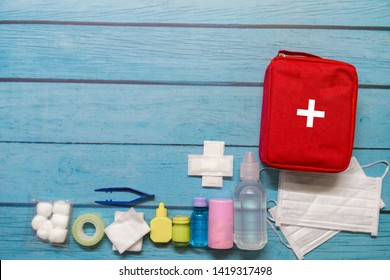 Top View First Aid Bag Kid With Medical Supplies  On Wood Background.