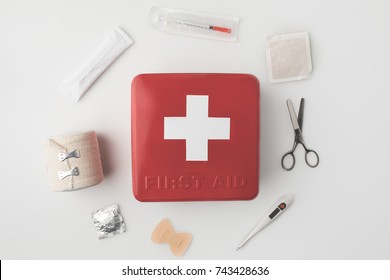 Top view of first-aid kit with medical supplies around