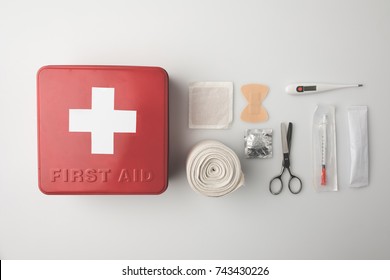 Top view of first-aid kit with patch, scissors, thermometer and elastic bandage