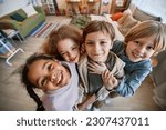 Top view fisheye at diverse group of happy children looking at camera together and smiling