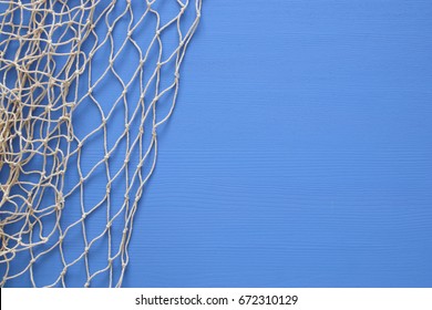 Top view of Fishnet on blue wooden background.