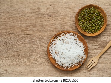 Top View Or Flat Lay Asian Vermicelli Or Cellophane Noodles And Mung Green Bean In Wooden Plate On Wood Table Overhead Background. Glass Noodle                                              