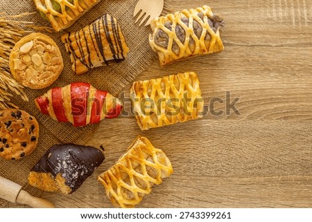 Top view flat lay of Assorted fresh bakery pastries and cookies arranged on a rustic wooden table