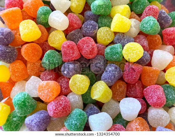 top view flat
lay background bright red, yellow and yellow Natural Fruit gum
drops coated in granulated
sugar