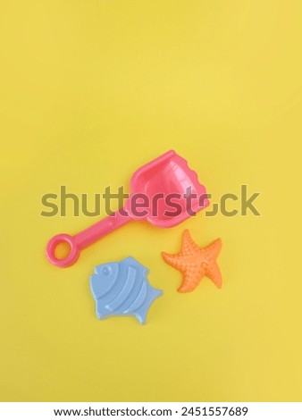 Top view and flat lay beach tools for kids on yellow background