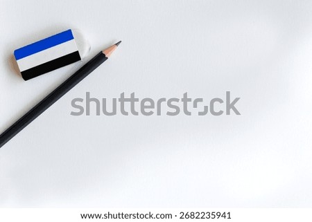 Top view flat lay of a black pencil and eraser on a clean white paper background with copy space. Minimalist concept for education, back to school, office, writing, or creative ideas.