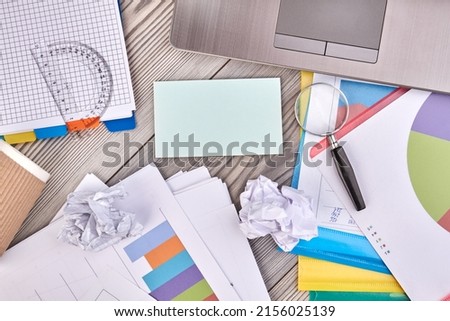 Top view flat lay blank paper for copy space and office stuff. Work papers with charts and glass magnifier.