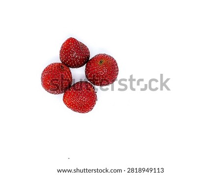 Top view flat lay composition of four fresh whole ripe strawberries isolated on a clean white background