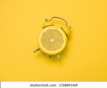 top view flat lay creative art collage alarm clock with lemon slice  on a yellow  background,summer bright poster 