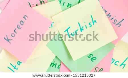 Top view flat lay of diferent languages english which written on the reminder notepaper of different colors
