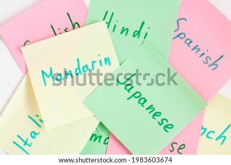 Top view flat lay of different languages such as Mandarin and Japanese which written on the reminder notepaper of different colors. Flashcards and language studies concept concept.