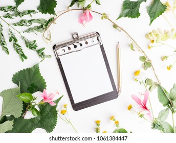 Top view flat lay empty notepad with summer leaves and daisy flowers mockup. Text space