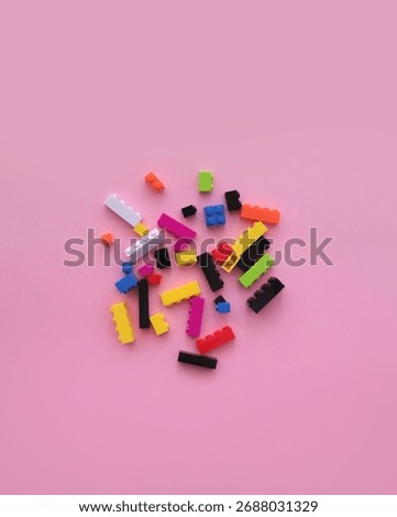 Top view and flat lay of a group of colorful lego brick blocks on pink background
