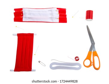 Top View Flat Lay Of Hand Make Surgical Style Face Mask With Bright Red Cotton Fabric. Supplies Elastic, Thread, Bobbin, Pins, Scissors And Safety Pin To Thread Elastic.