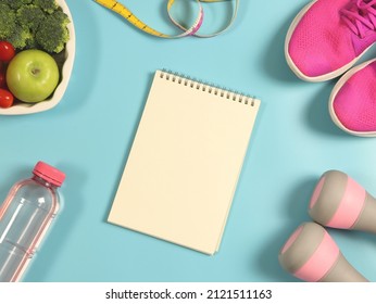 Top View Or Flat Lay Of Open Notebook, Vegetables And Fruit In Heart Shape Plate, Bottle Of Water, Measuring Tape,  Pink Dumbbells And Pink Sneakers On Blue  Background. Healthy Lifestyle.