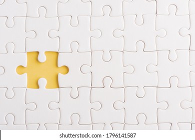 Top view flat lay of paper plain white jigsaw puzzle game texture incomplete or missing piece, studio shot on a yellow background, quiz calculation concept
