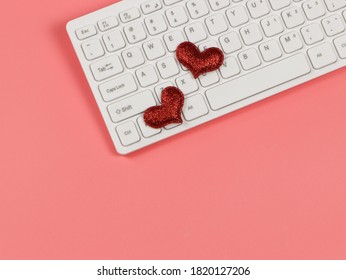 Top view or flat lay of red glitter heart on computer keyboard , on pink background. online dating and long distance relationship concept.