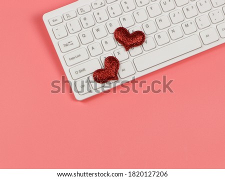 Top view or flat lay of red glitter heart on computer keyboard , on pink background. online dating and long distance relationship concept.