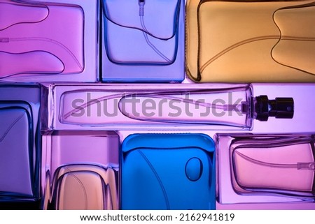 Top view, flat lay of a set of perfume bottles on a purple background.