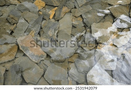 top view and flat lay a stone background is under a river or waterfall. the water from the river is crystal clear, where you can see the river rocks under the water.
