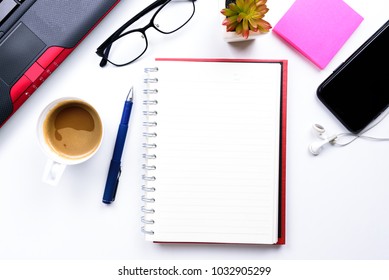 Top view or Flat lay style for business with copy space of workspace with laptop , pen , notebook , cup of coffee , sticky note eyeglasses and mobile phone and earphone on white table background 