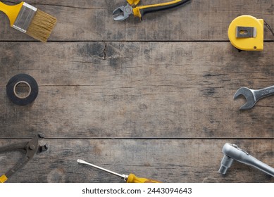 Top view flat lay of tools composition on a wooden table. Copy space in the middle. Ideal for DIY concept promotion