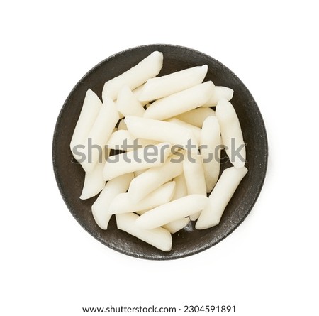top view flat lay Tteok or Korean Rice Cakes in plate isolated on white background. pile of Tteok or Korean Rice Cakes in dish isolated on white background. Tteok Korean Rice Cakes