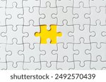 Top view flat lay of white jigsaw puzzle game texture incomplete or missing piece on a yellow background.