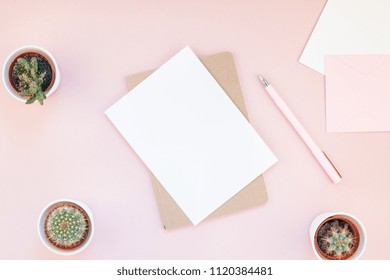 Top view flat lay of workspace desk styled design office supplies and cactuses succulents with copy space millennial pink color paper background minimal style. Template for feminine blog social media