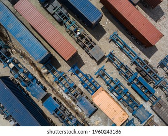 Top View Of Flatbed Semi Trailers And Containers For Rent Stored In An Empty Dirt Open Lot.